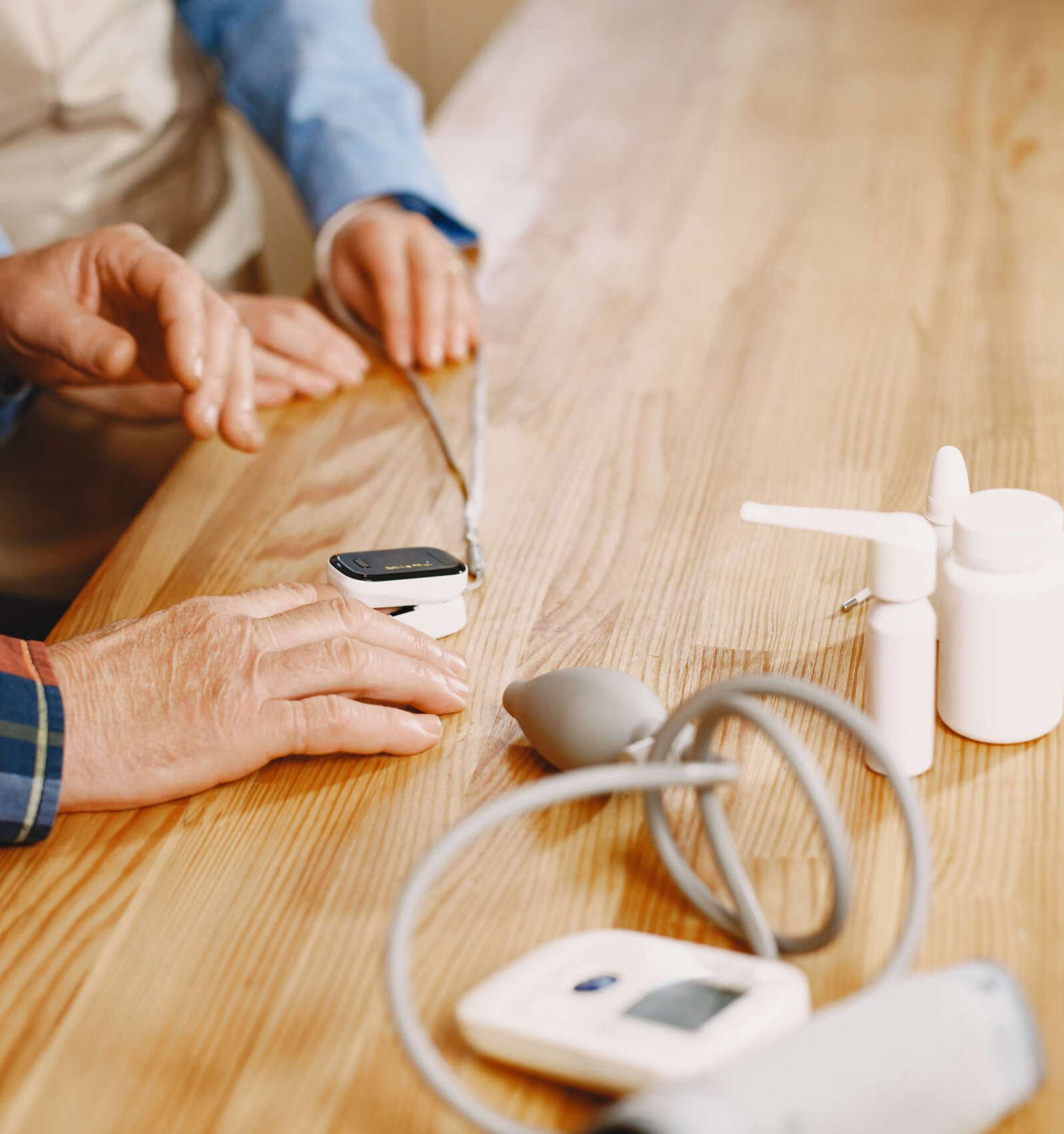 Old couple in a kitchen. Woman in a blue shirt and aprone. People in a medical masks.
